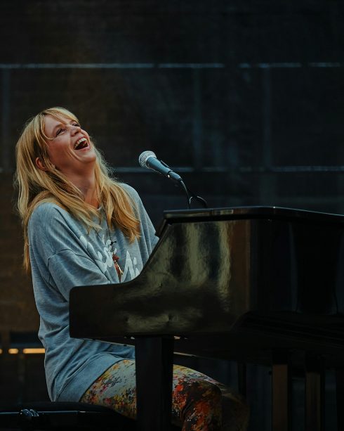 Coach singing at a grand piano