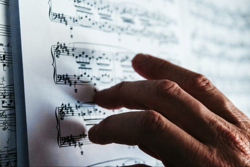 A hand resting on a page of sheet music